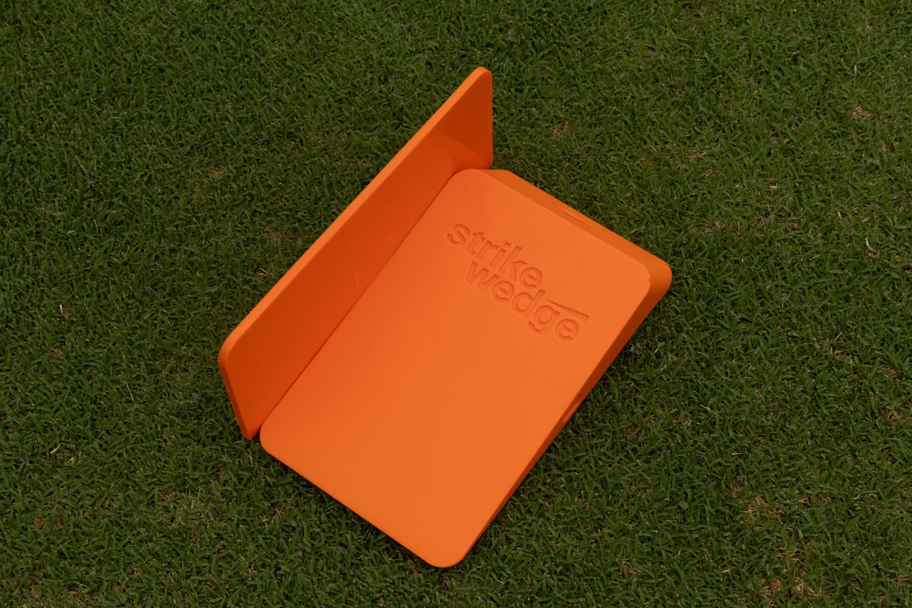 A genuine Strike Wedge open flat on the green, showing the embossed wordmark